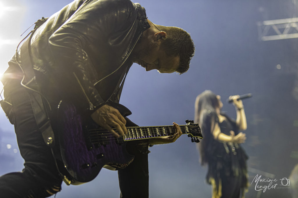 Guitariste d'Evanescence au premier plan et Amy Lee en fond